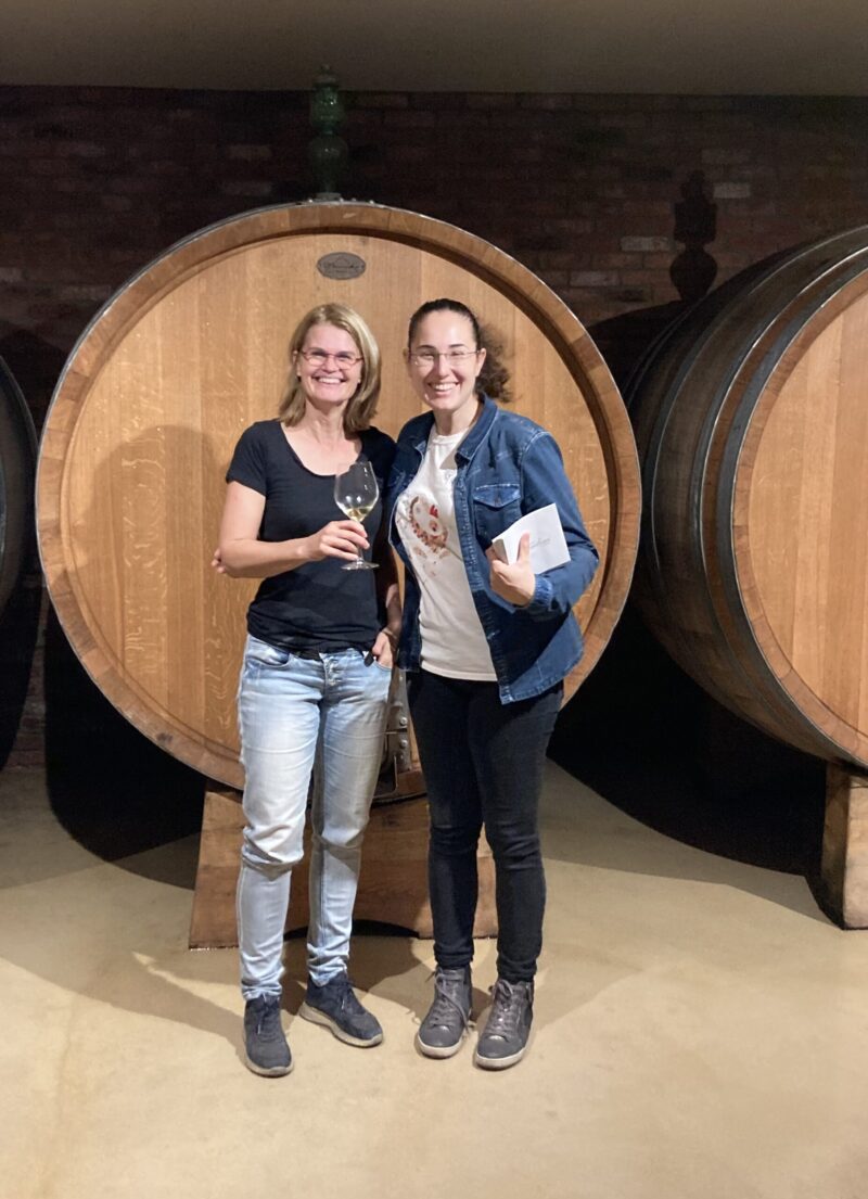 Céline en Ambra poseren voor een heel groot wijnvat bij Brandini