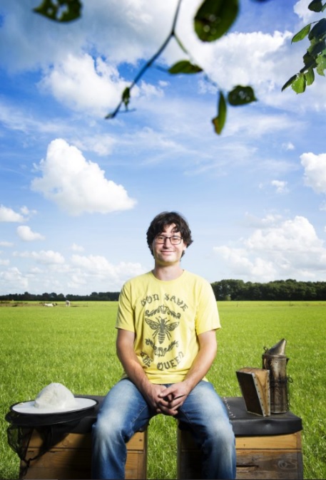 Imker Elmar Mook zittend bij zijn bijenkast in het veld